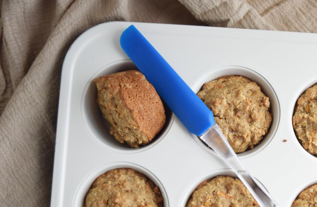 carrot cupcakes in muffin pan with spatula