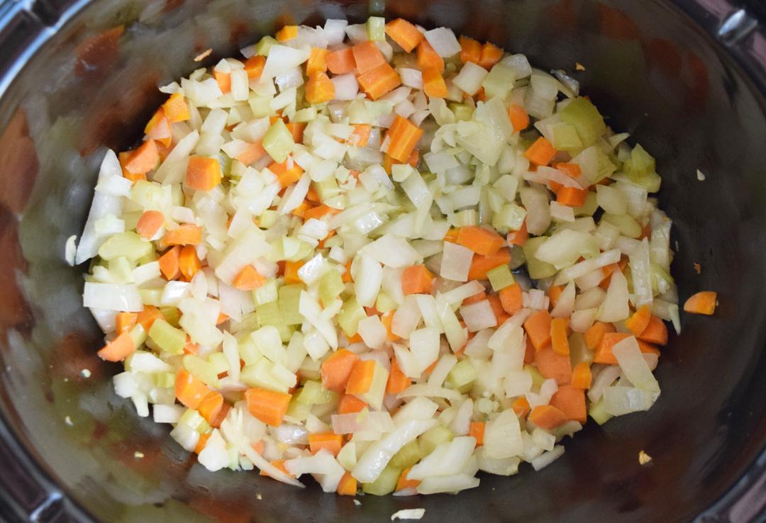 mirepoix ingredients stirred in slow cooker