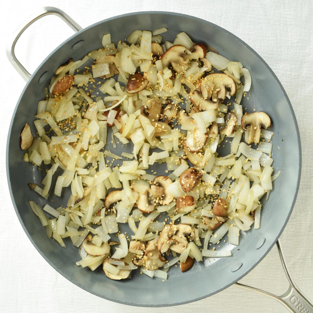 saute pan with cooked onions, mushrooms, and garlic