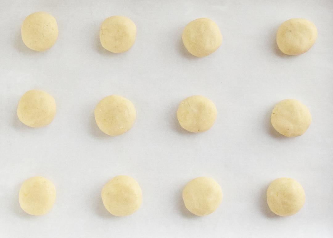 unbaked cookie dough balls on a cookie sheet