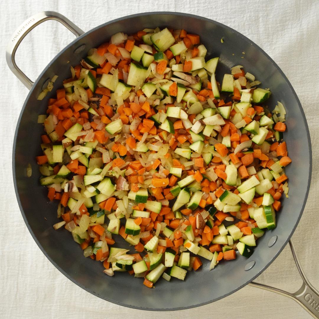 chopped vegetables sauteed in a pan